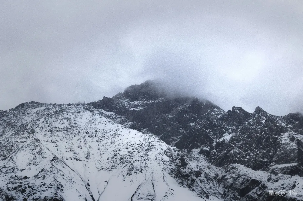 云雾笼罩下的雪山在阴天中