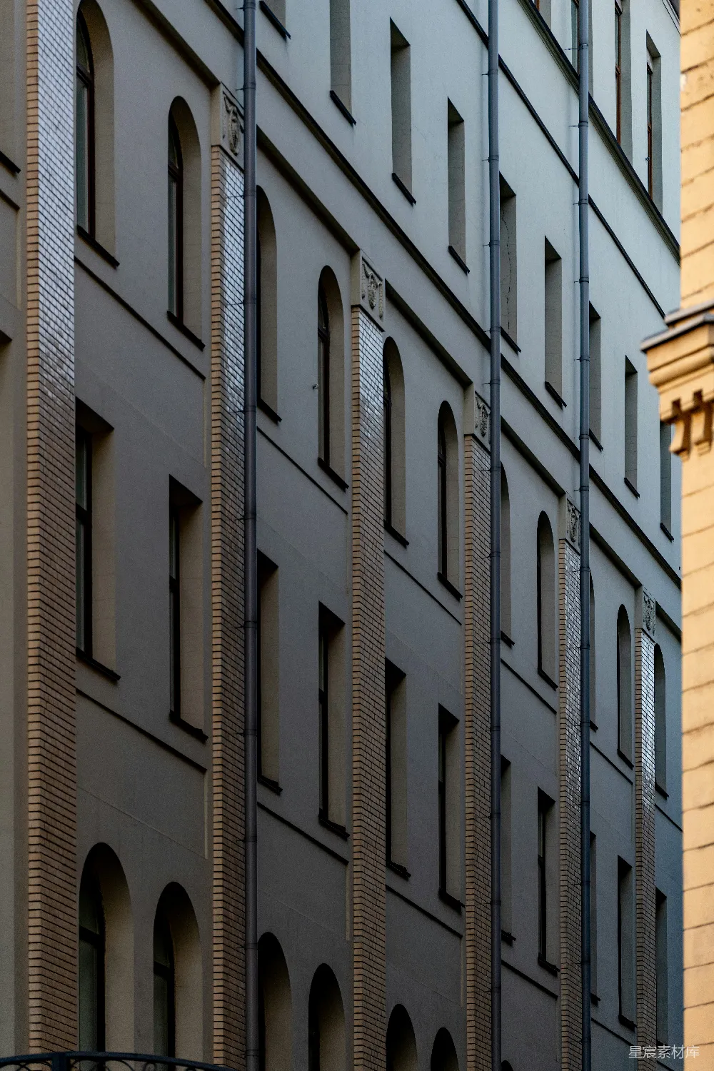灰色建筑立面排列着一排排拱形窗户。