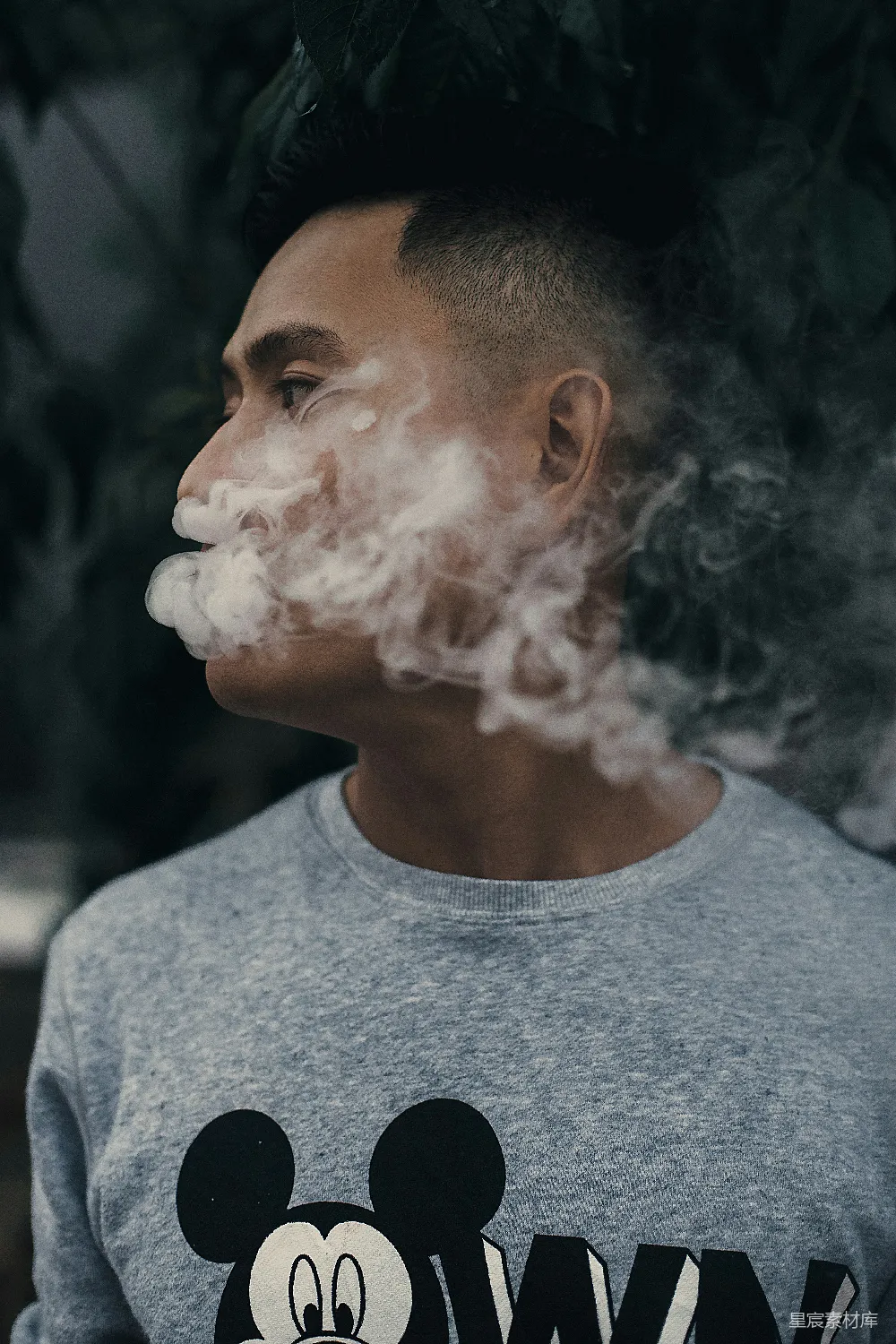 男人在看着右边时正在抽烟。