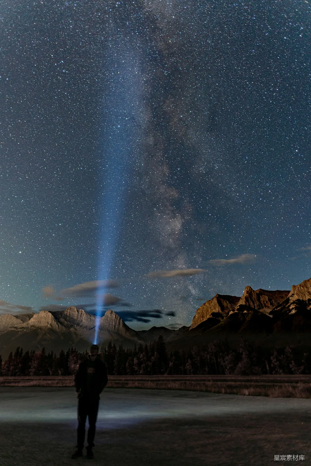 人在岩石山下夜晚星光下站立