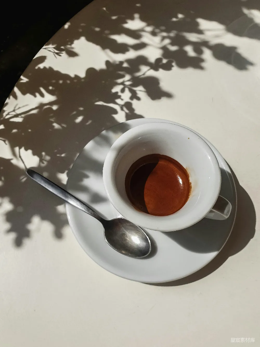 咖啡杯放在托盘上，旁边有一根勺子。