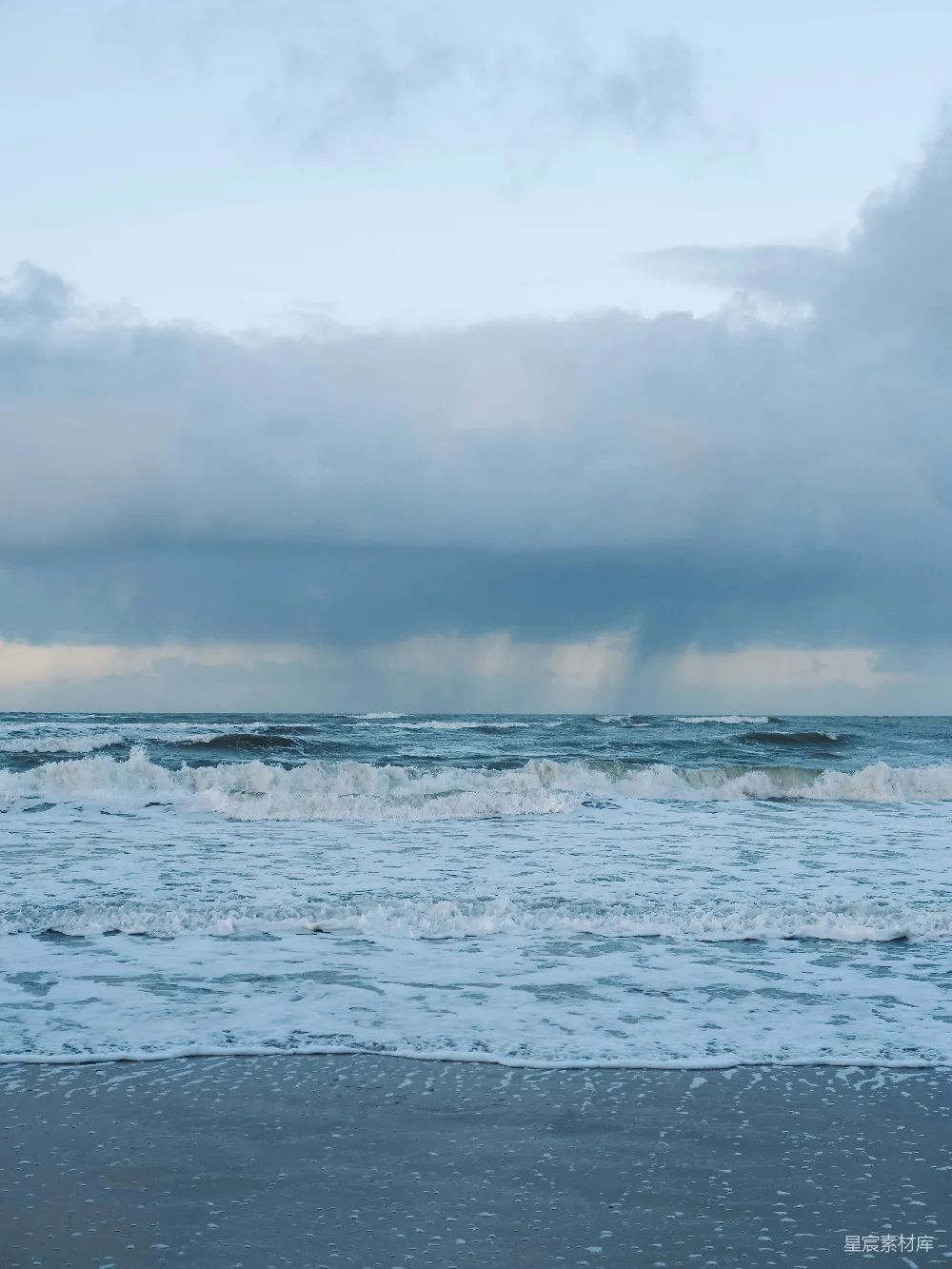 海滩上行走的人带着冲浪板
