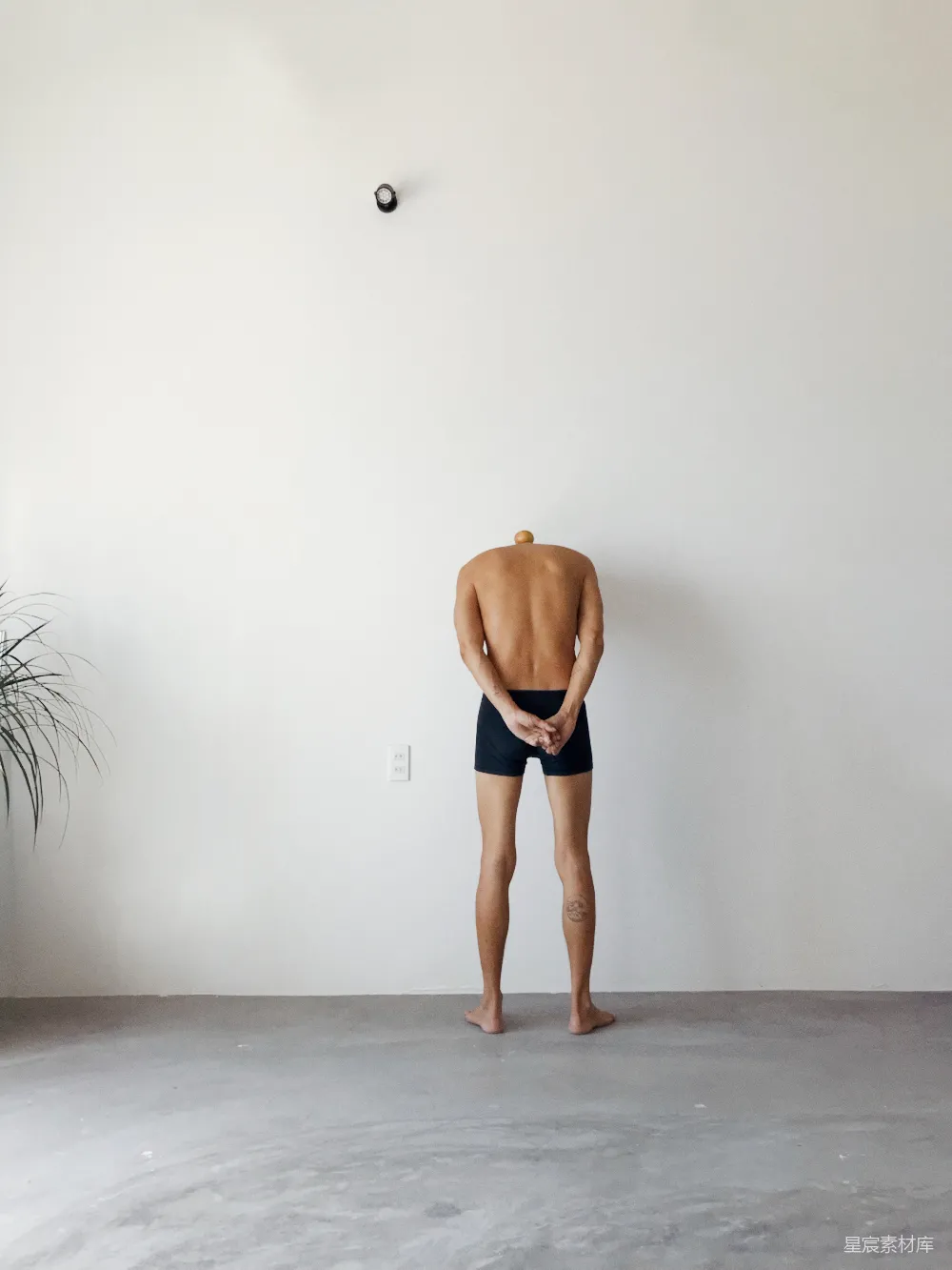 一个男人站在一面白色墙壁面前