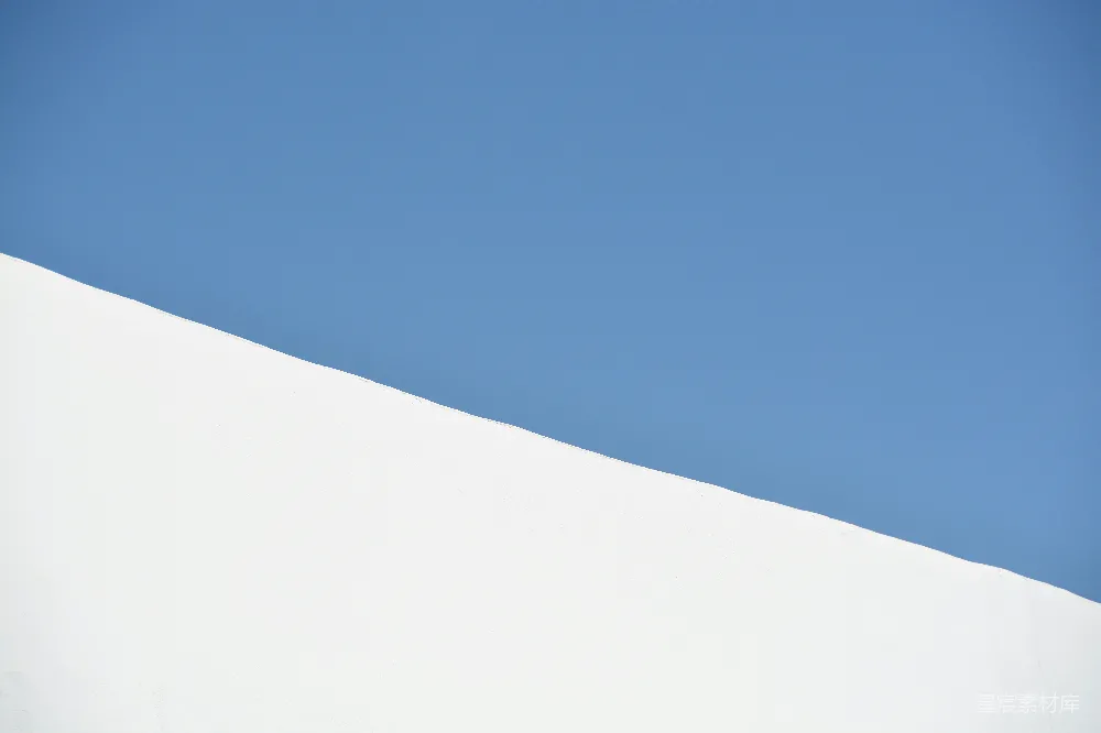 高清摄影  一个男人正在沿着覆盖着积雪的斜坡滑行滑雪板。