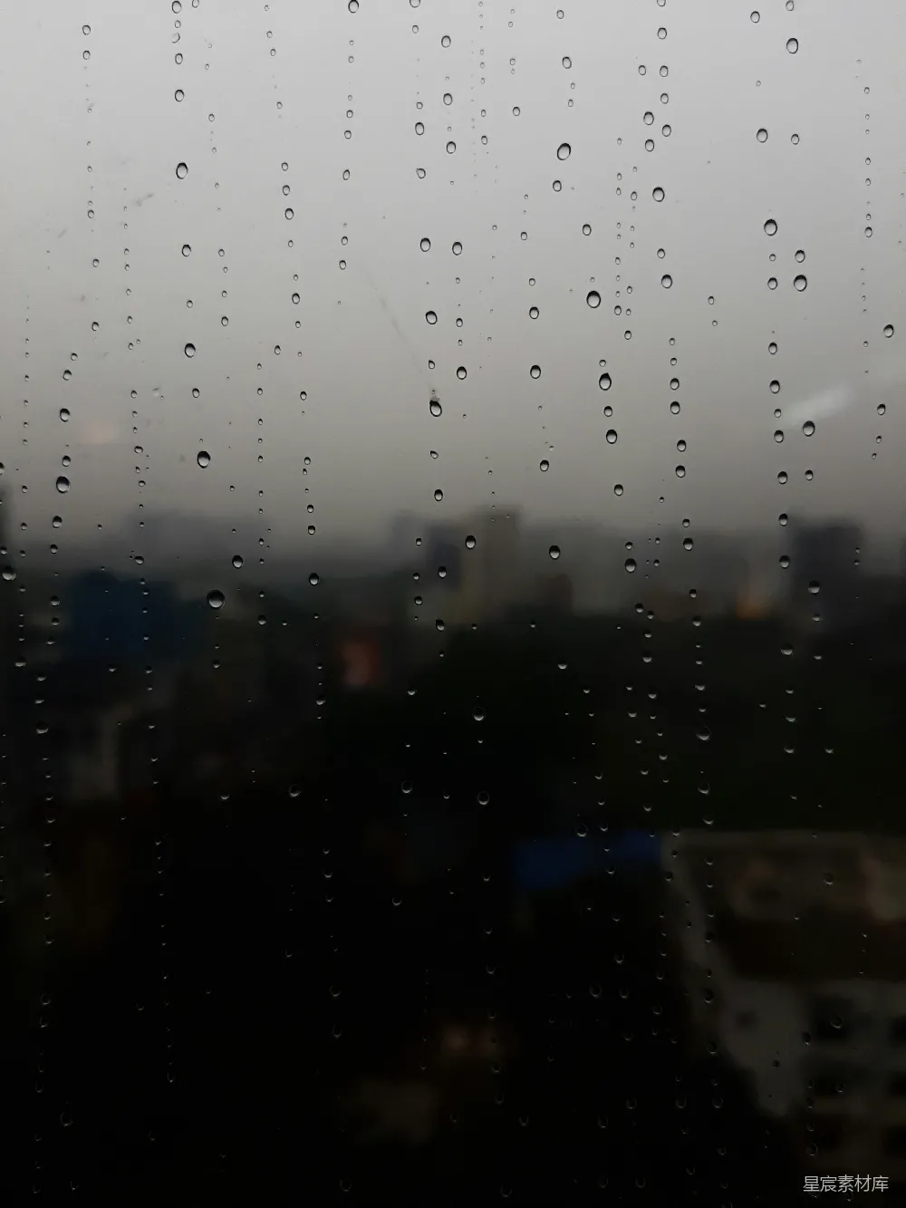 窗外的城市中有雨滴落下