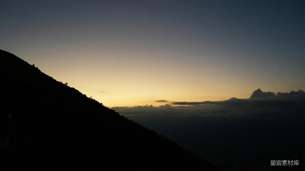 黑暗山影衬托着色彩斑斓的 sunrise 天空与云彩。