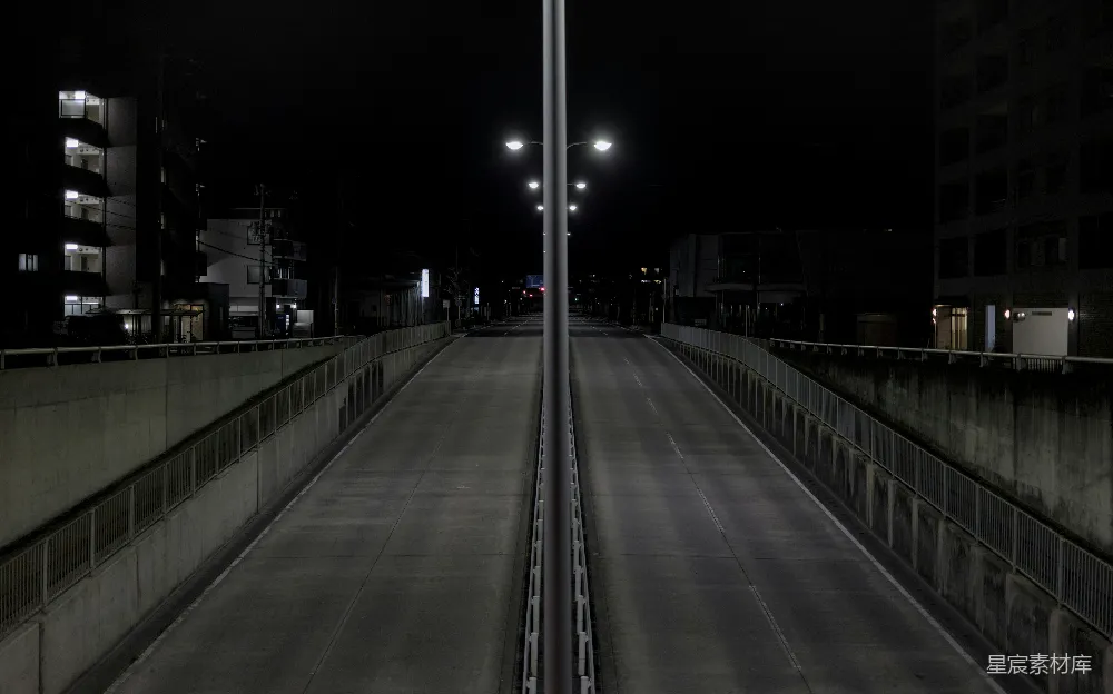 夜晚空寂的街道，路灯昏黄。