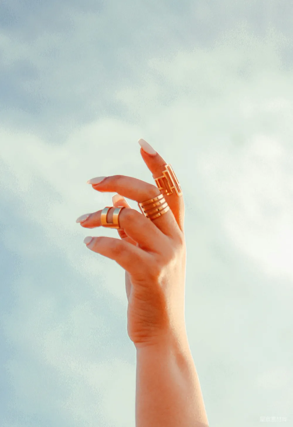 一个女人的手在空中拿着一枚戒指