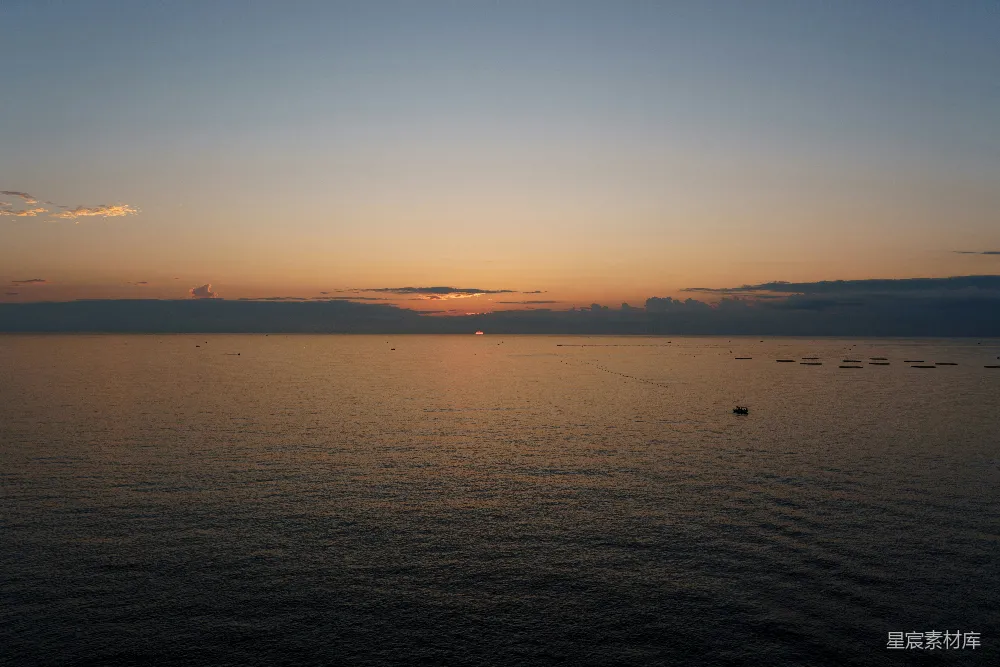 背景有一大片水面以及夕阳的倒影。