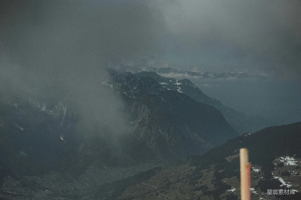 一幅山峦景色图，天空中有云。