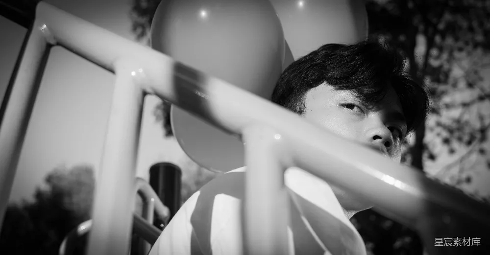 高清摄影  一张黑白照片，一个男人手里拿着一个气球。