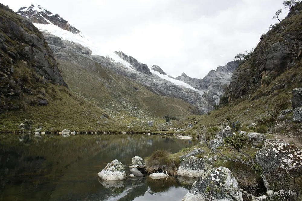 湖中间一片绿草地上方有山峦