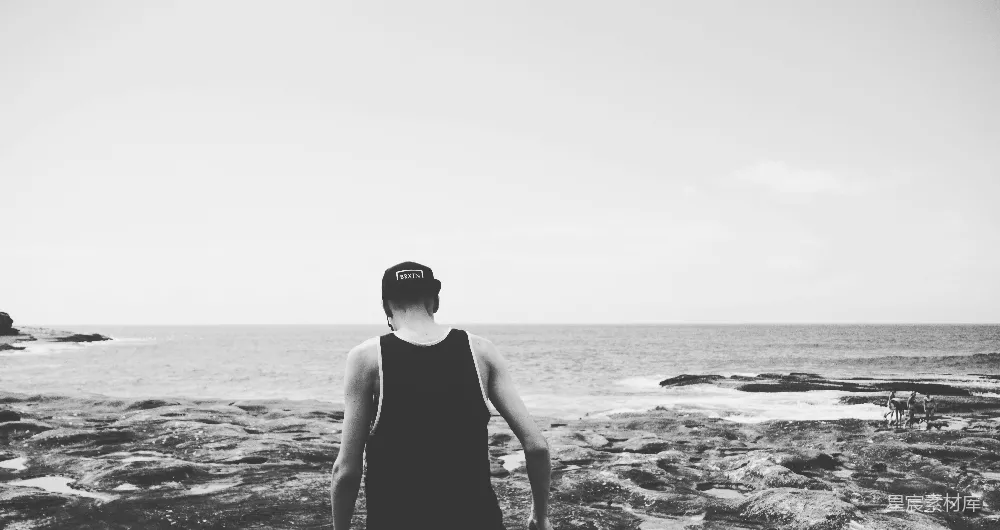 高清摄影 人物 黑白色调的男子在岸边行走的照片