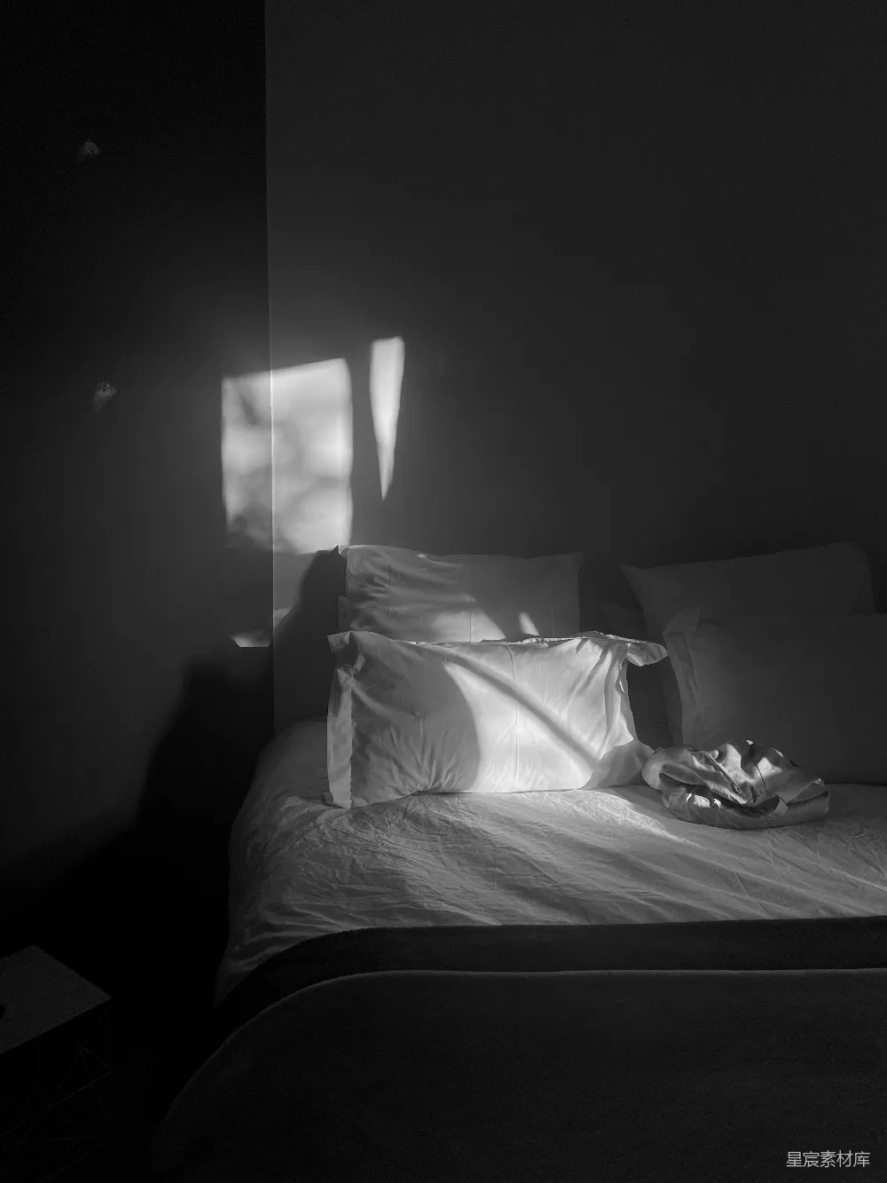 高清摄影  一张黑白色调的卧室照片，床上空无一人。