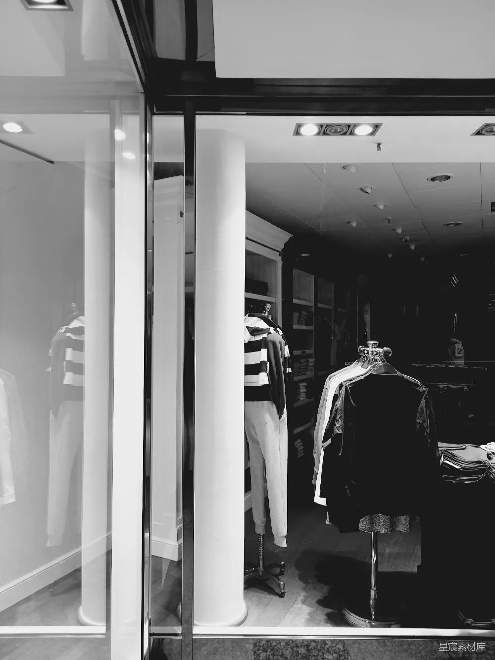 高清摄影  一张黑白照，展示了一家服装店的场景。