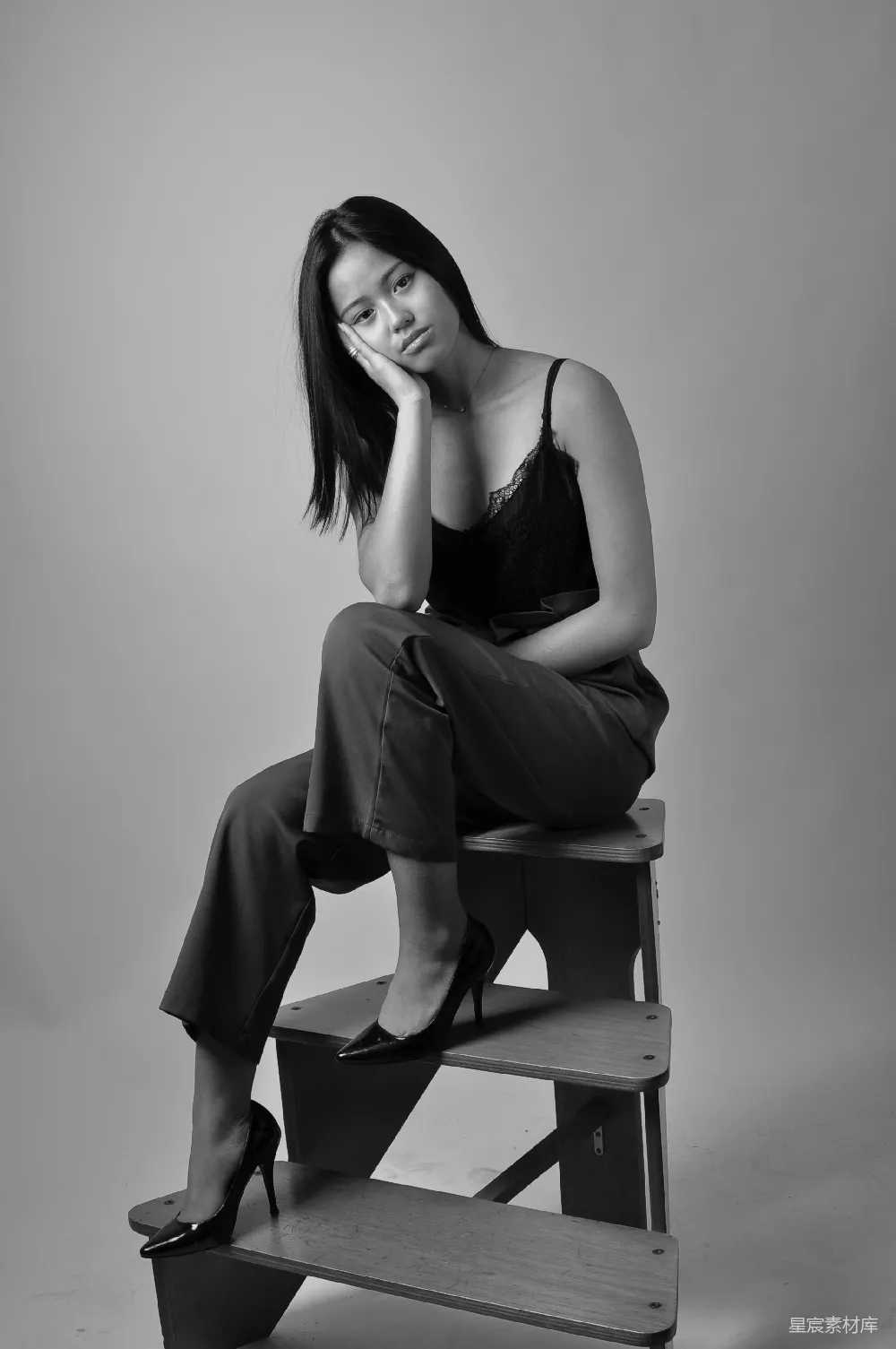 一个女人坐在一块木制长凳上。