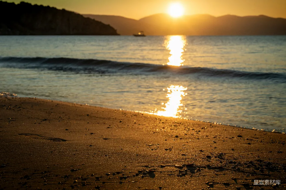金色夕阳映照平静的海洋，一艘船。