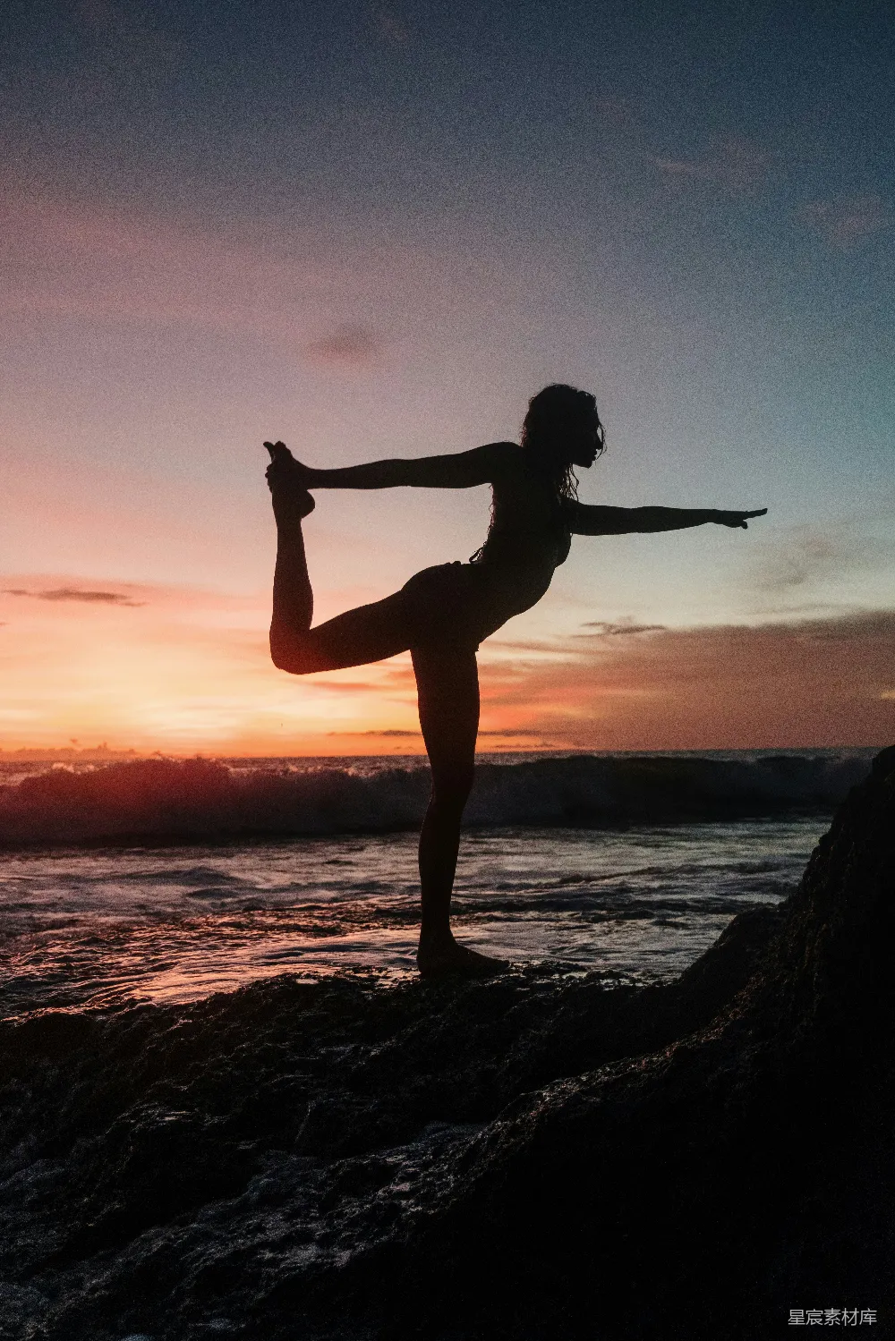 夕阳下女人站立在岩石上的轮廓