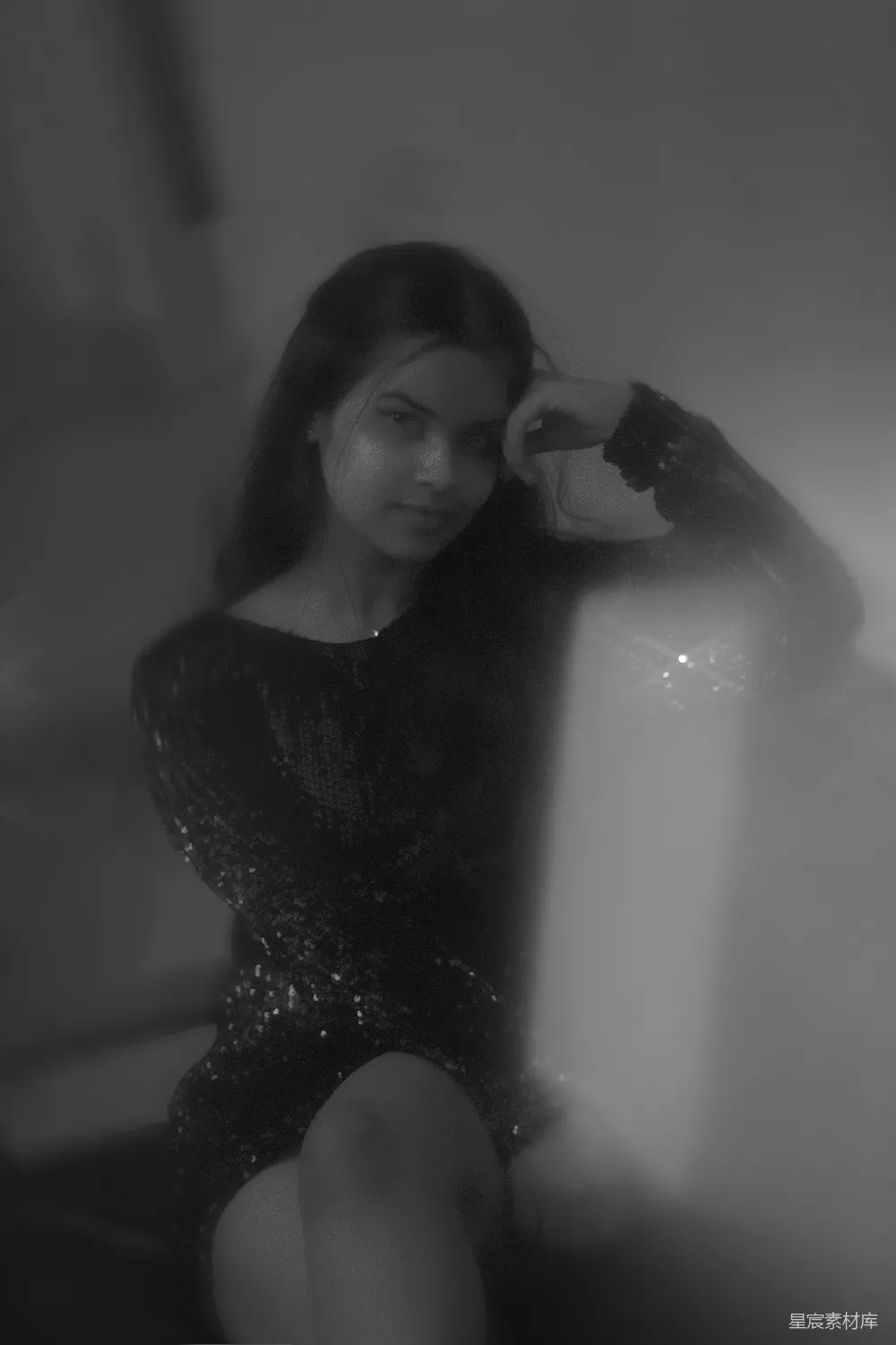 高清摄影  一位穿着黑色连衣裙的女士坐在椅子上。