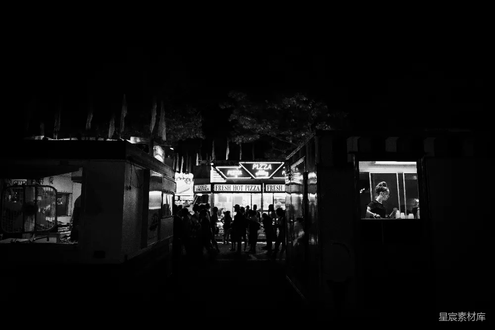 高清摄影  夜间街道上行走的人的黑白照片