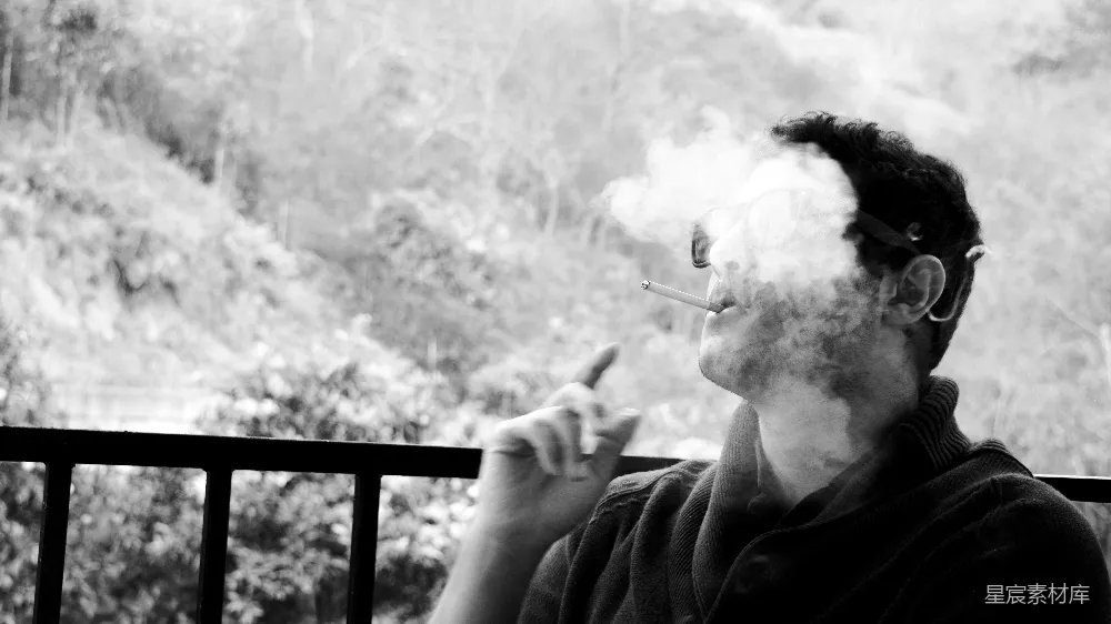 高清摄影  一个男人在阳台上抽着香烟。