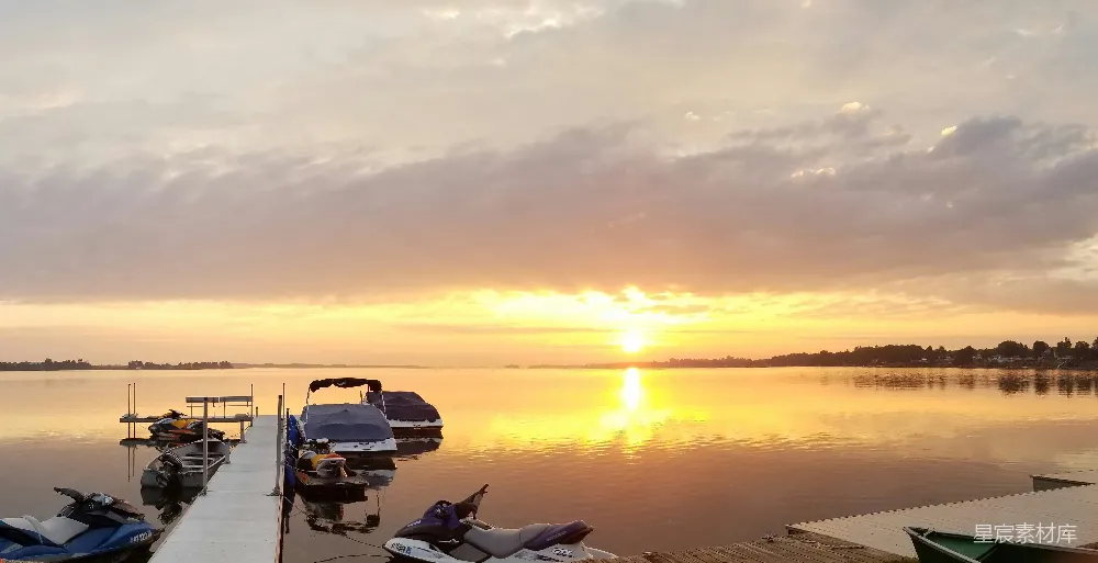 夕阳下的码头上有几艘船停泊着。