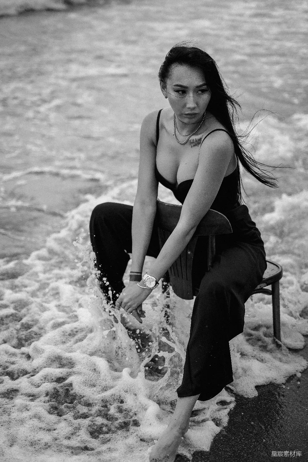 高清摄影  穿着黑色背心的女子坐在海滩上的椅子上
