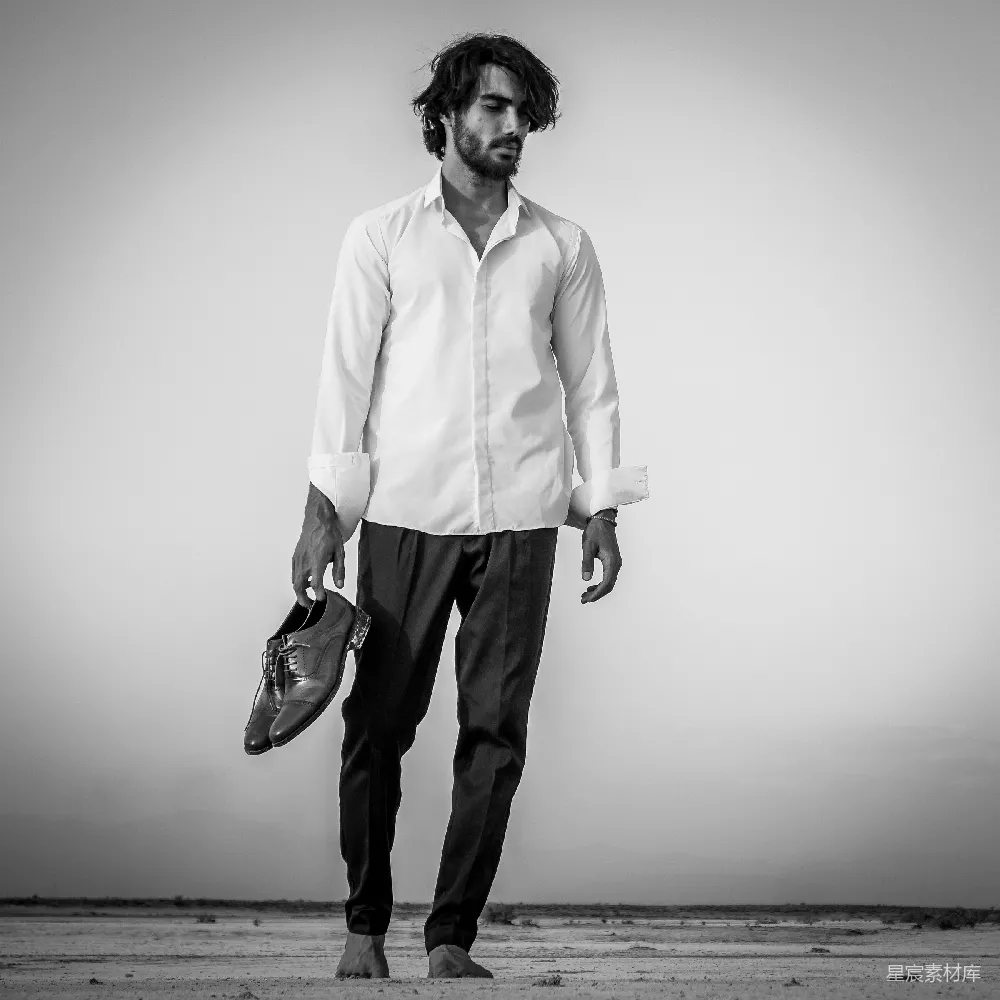 高清摄影 人物 一个男人站在沙滩上，手里拿着一个棒球手套。