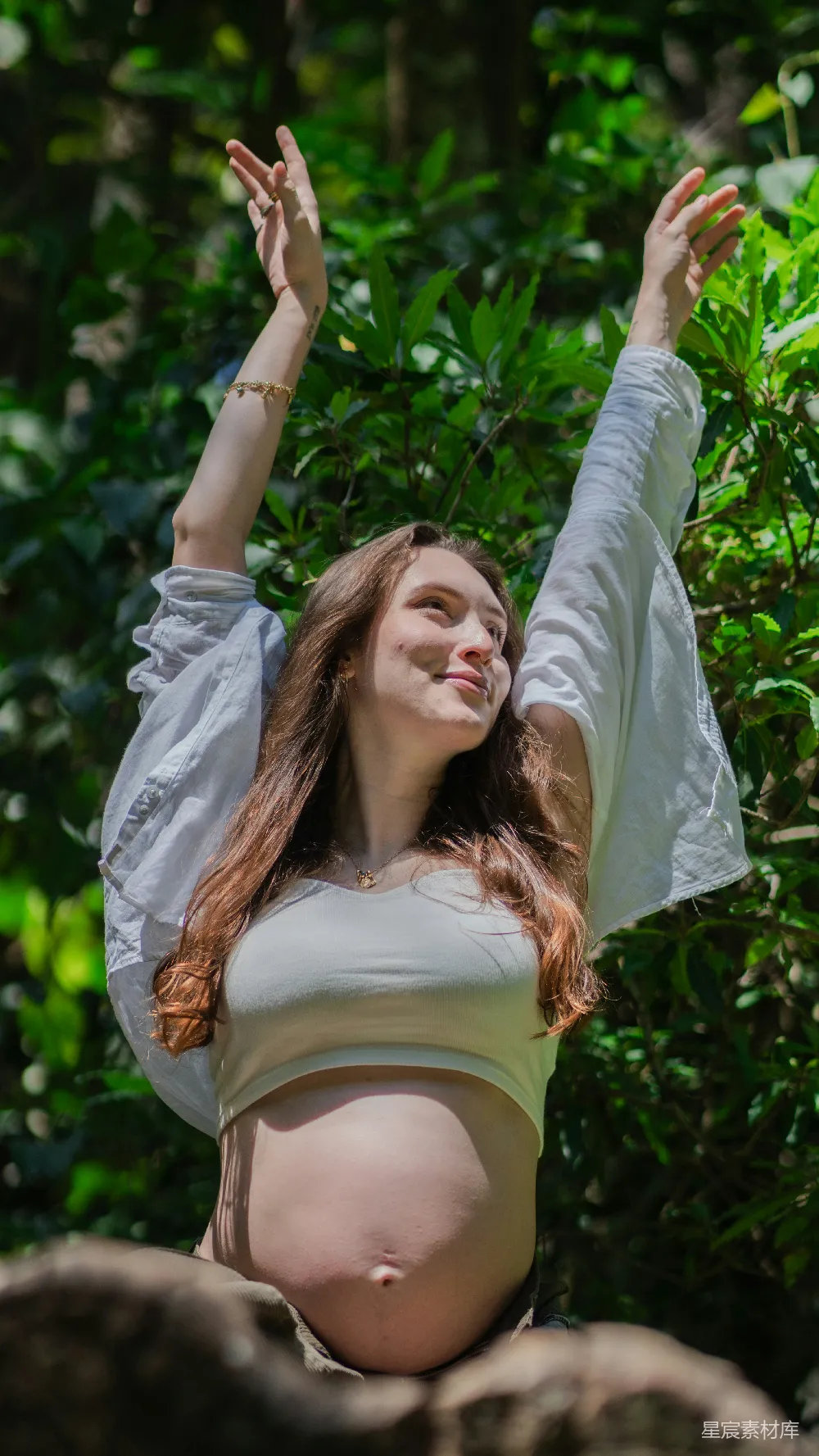 怀孕妇女举手在大自然中