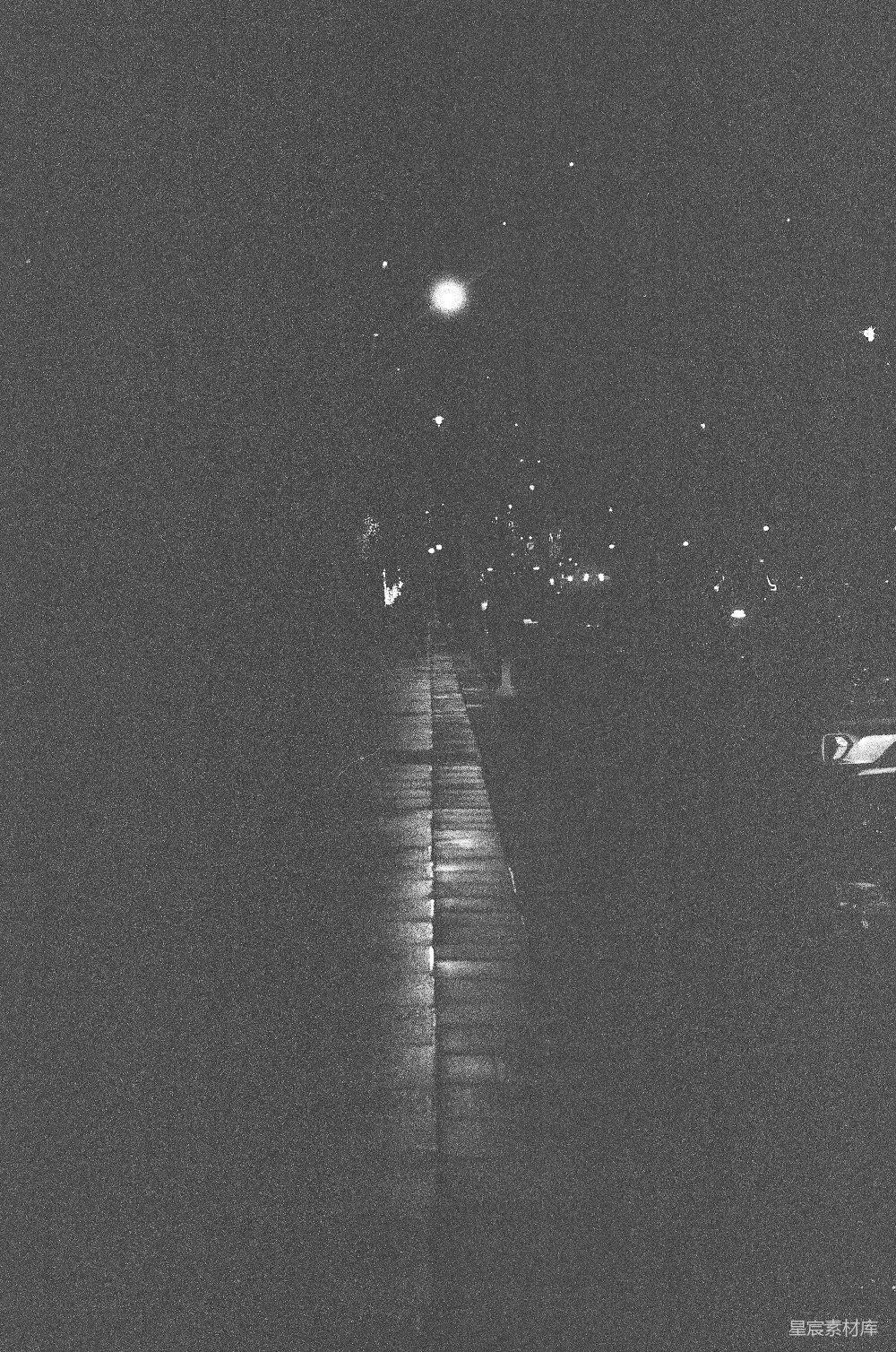 高清摄影  夜晚一条昏暗的街道，旁边有人行道。