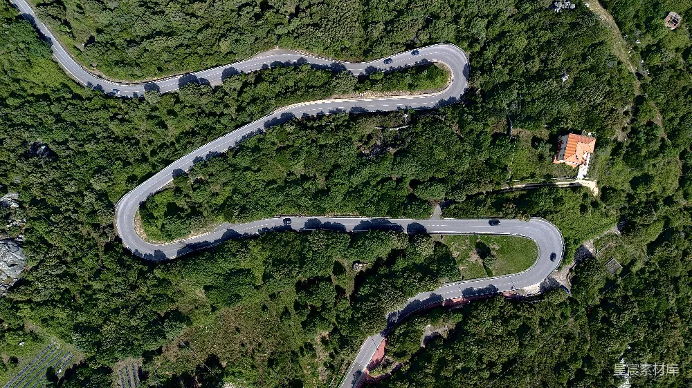 高清摄影  一条蜿蜒的公路俯瞰图，两旁环绕着树木。