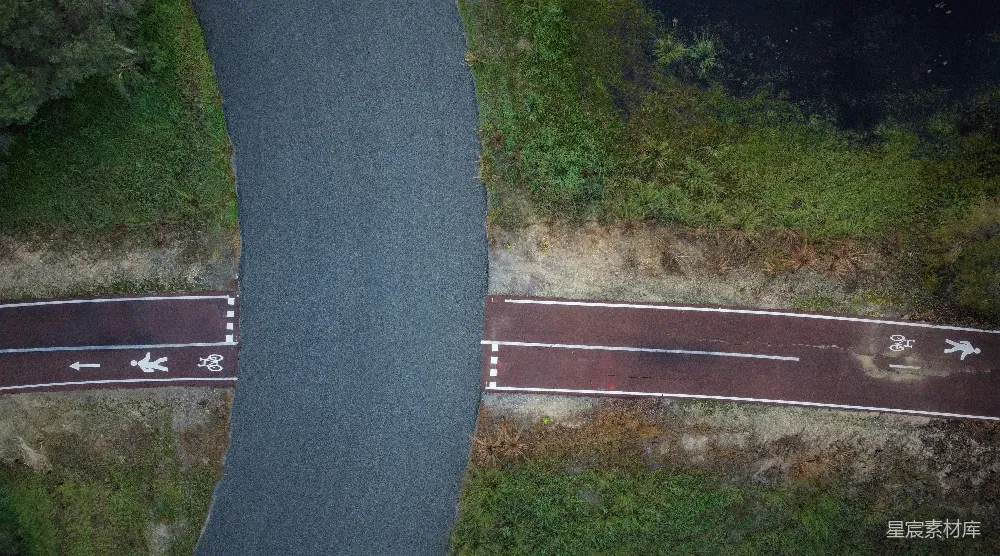 高清摄影  一条路上有两条箭头涂在上面的空中俯瞰视角。