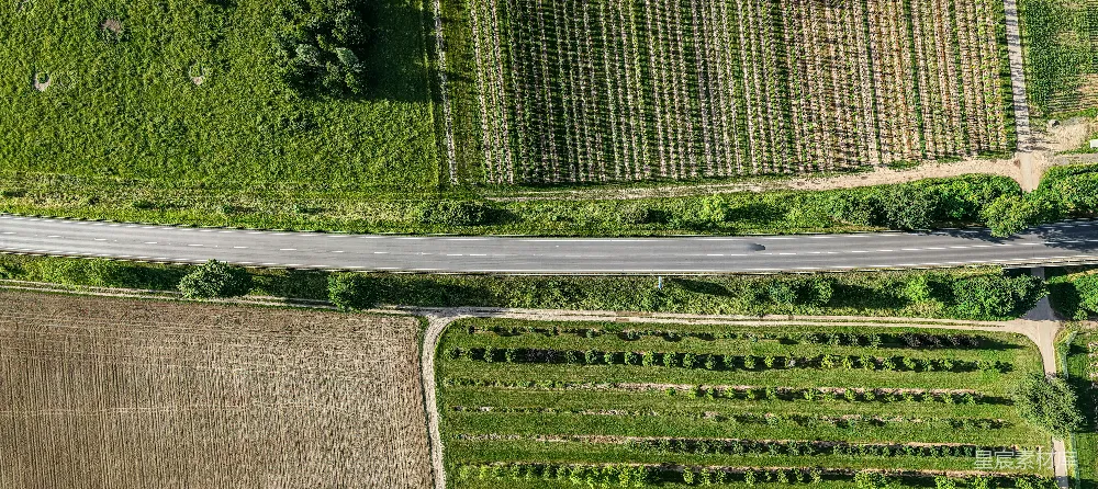 高清摄影  一条道路穿越不同类型的农田的鸟瞰图。