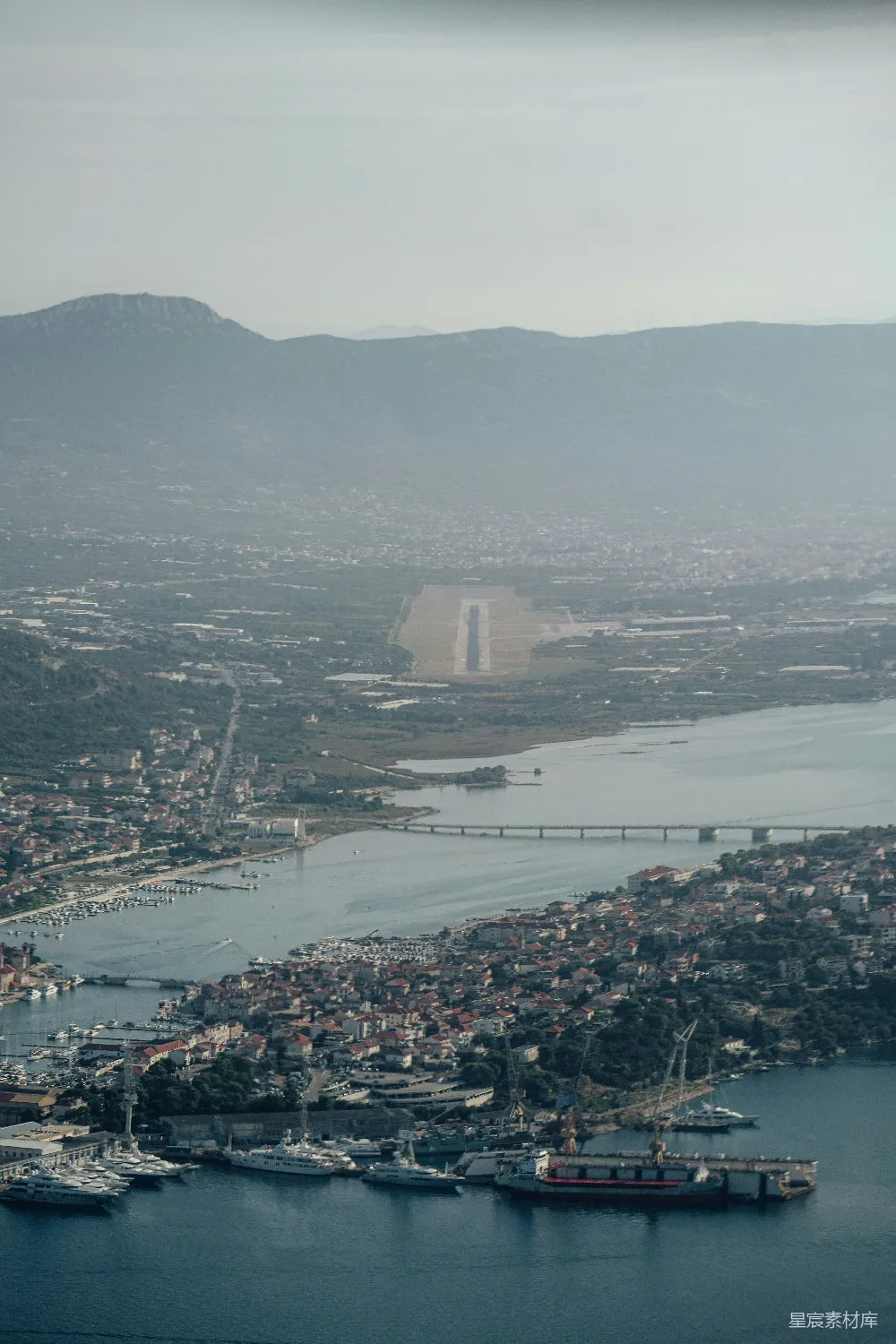 高清摄影  航拍视角下的海滨城市，可以看到机场跑道。
