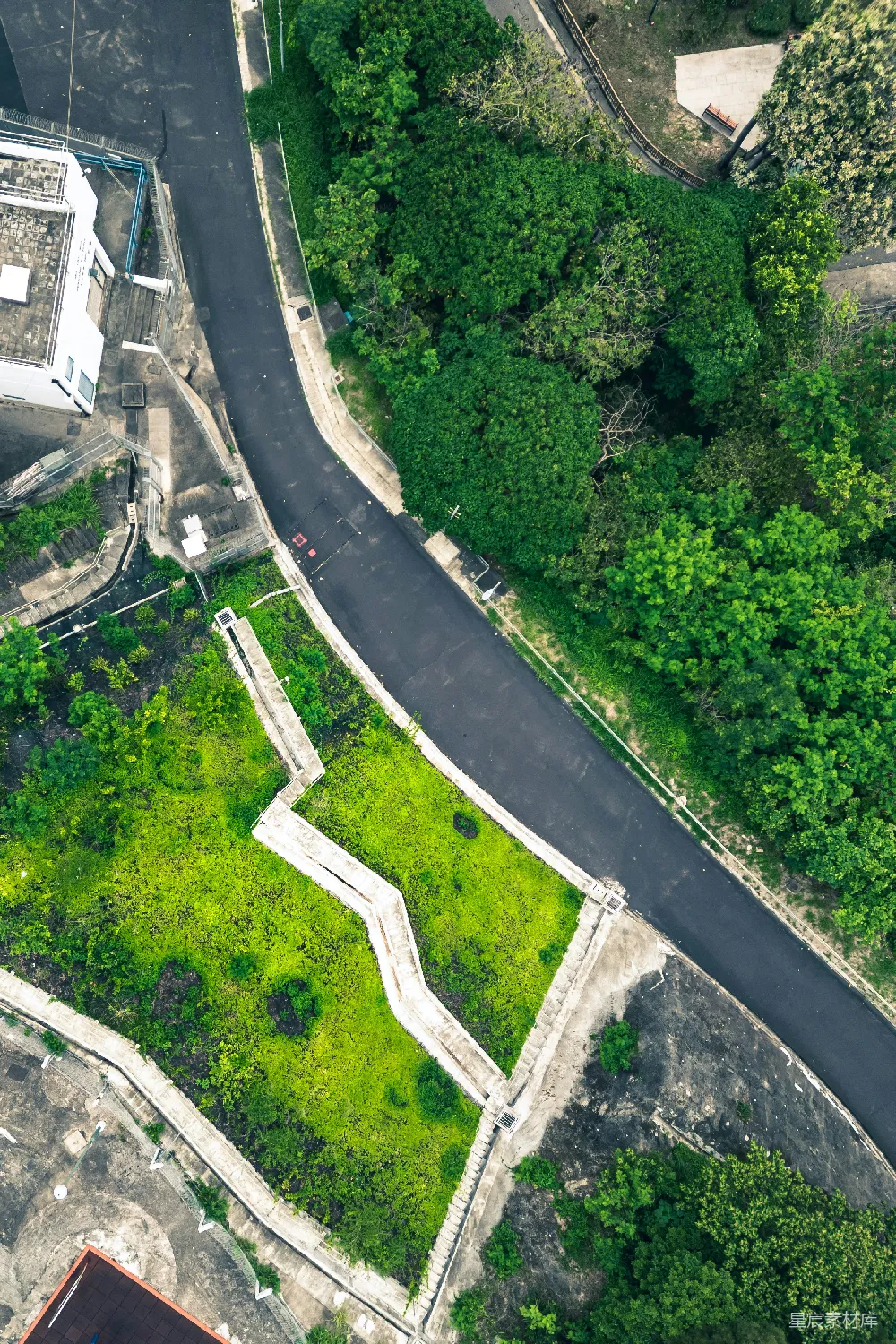 高清摄影  蜿蜒的道路、绿地和树木的俯瞰图。