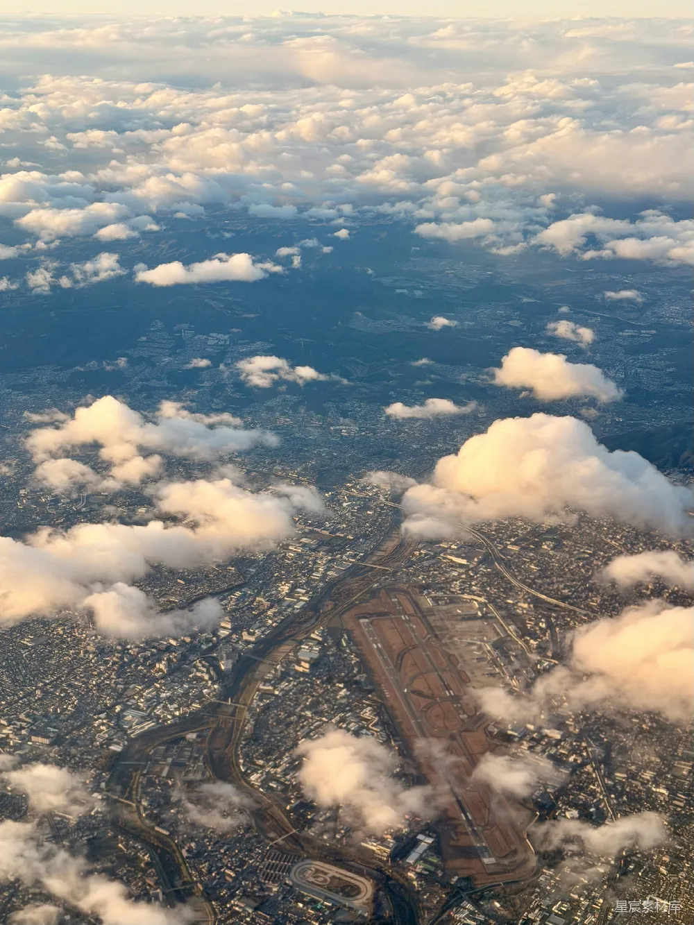 高清摄影  机场跑道的航拍图，周围环绕着云层。