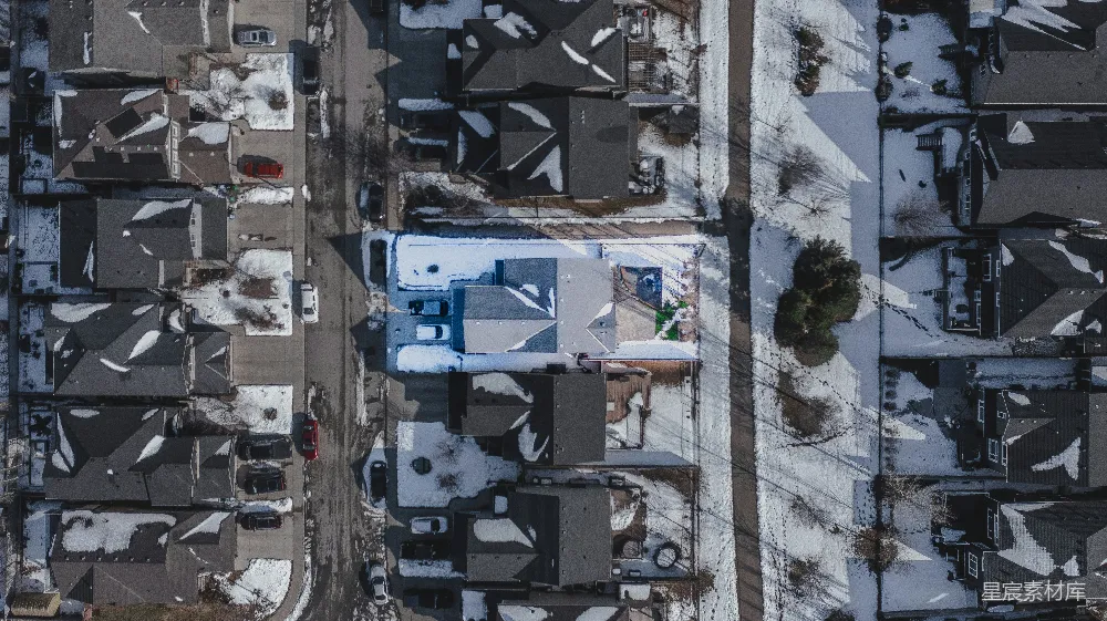 高清摄影  白雪覆盖的住宅区，从上方俯瞰房屋和街道。