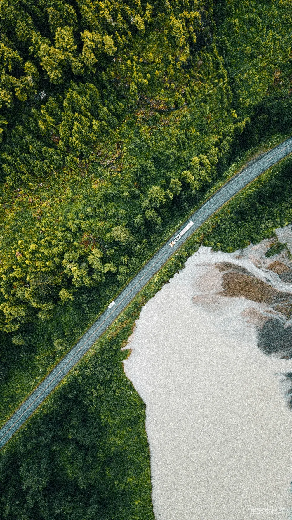 高清摄影  森林中穿过河流旁的道路俯瞰图