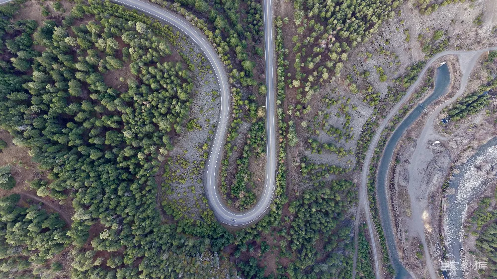 高清摄影  一条蜿蜒的道路穿过森林的俯瞰图