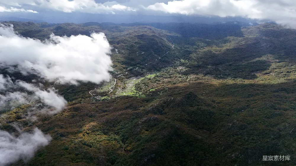 高清摄影  一片郁郁葱葱的山谷俯瞰图，周围环绕着群山。