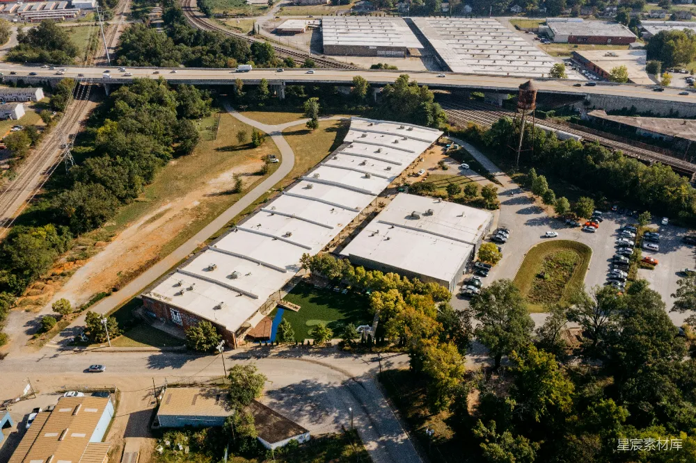 高清摄影  工业建筑的俯瞰图，周围环绕着树木和道路。