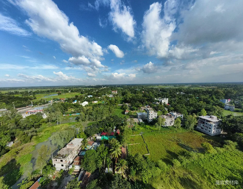 高清摄影  在一片绿意盎然的景观中，建筑物沐浴在多云的蓝天之下。