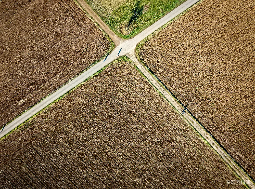 高清摄影  道路穿过耕作过的农田。