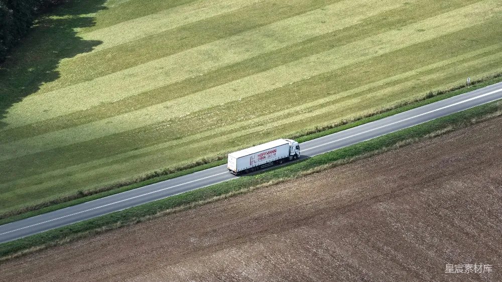 高清摄影  一辆白色的卡车在田野间行驶的道路上行驶