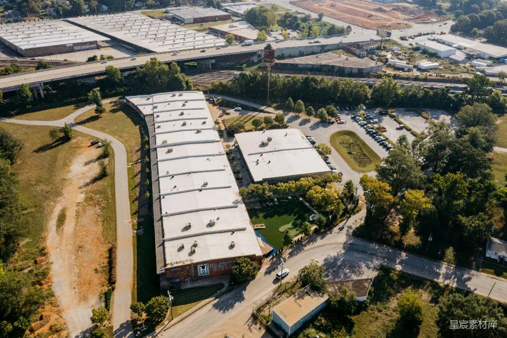 高清摄影  俯瞰一张长形工业建筑和停车场的照片。