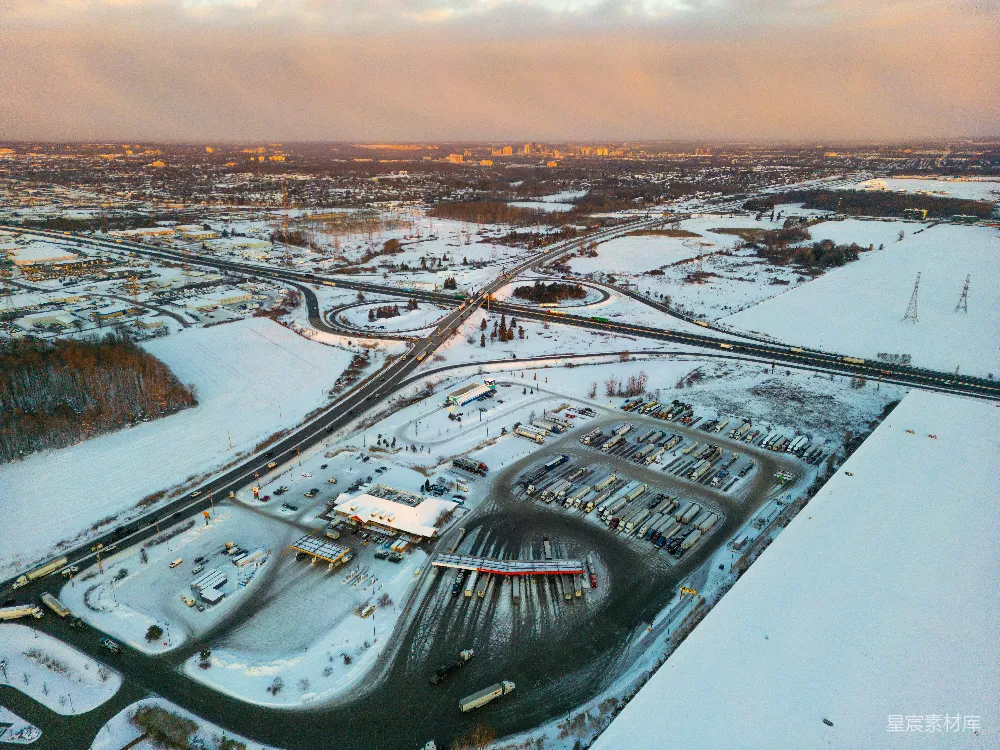 高清摄影  夕阳下的雪地高速公路互通鸟瞰图。