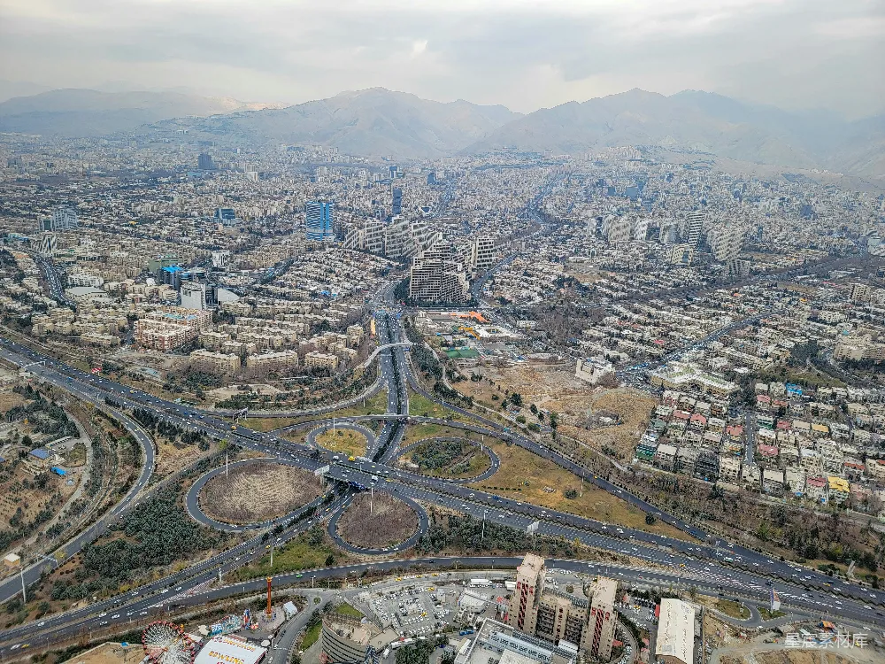 高清摄影  城市航拍图，道路和山脉交织其中。