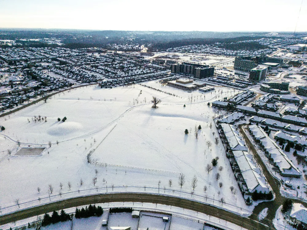 高清摄影  雪覆盖的郊区居民区和公园的空中俯瞰图。