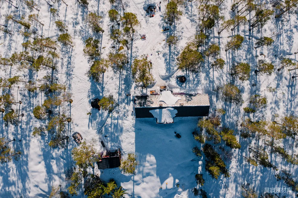 高清摄影  雪地森林中的一座小屋的航拍视角。