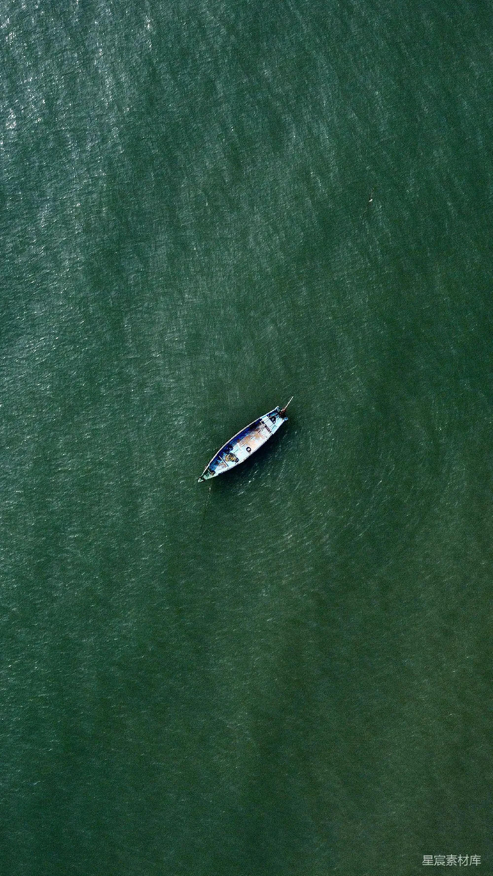 高清摄影  一艘小船漂浮在一片大水域上。